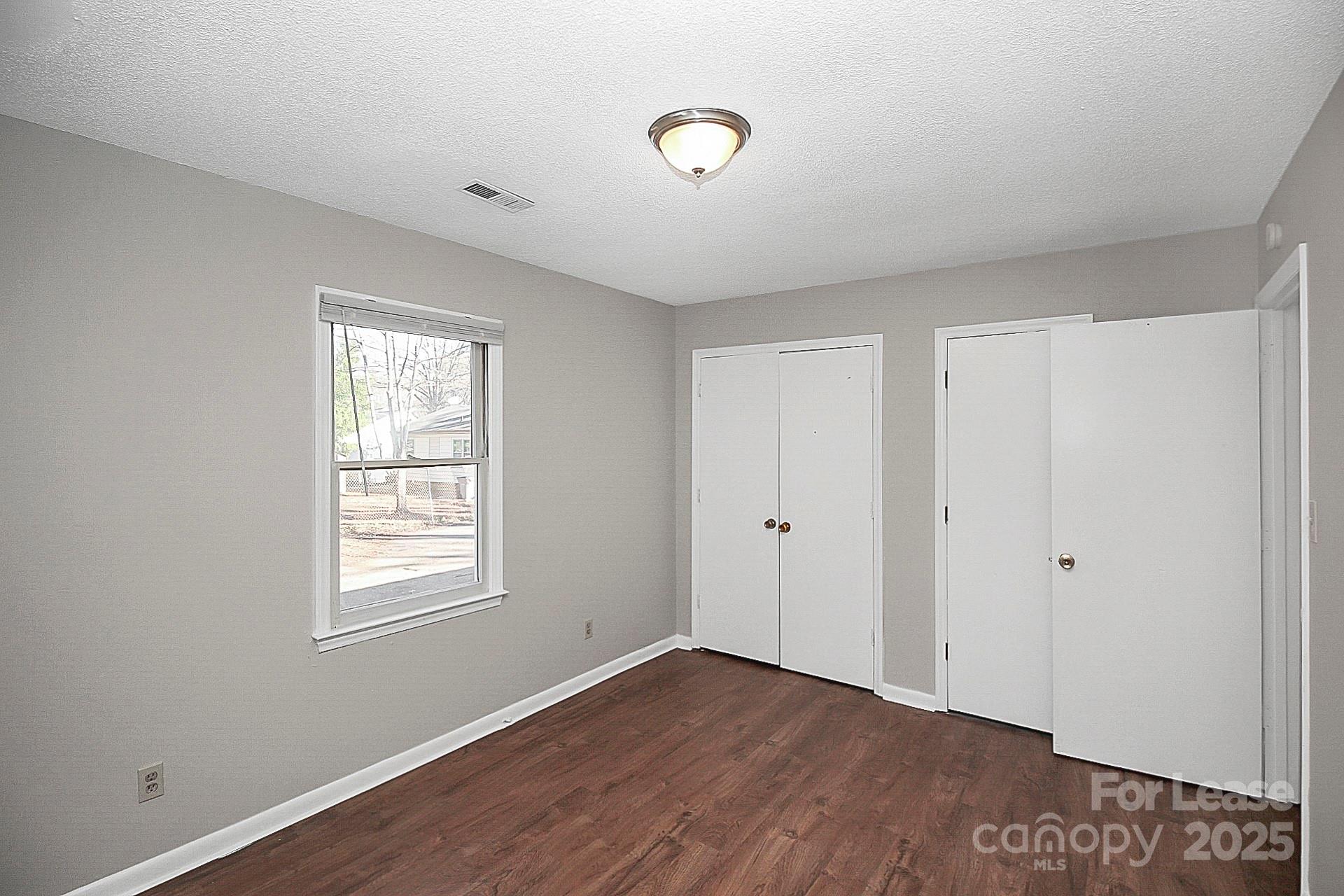 501 North Ransom Street, Unit C Gastonia, NC 28052 - Photo 11 of 19 a view of an empty room with wooden floor and a window