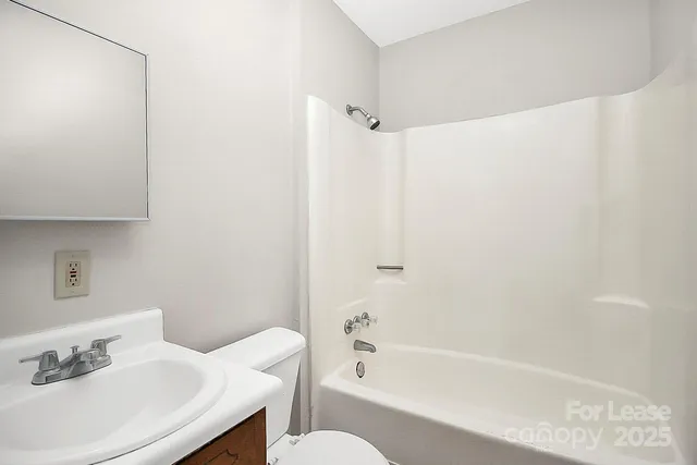 a white bath tub sitting next to a white sink and a shower