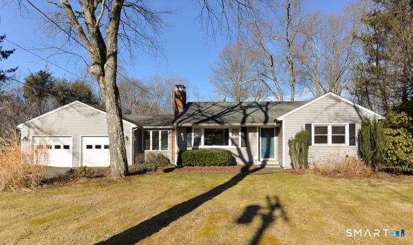 a front view of a house with a yard covered in snow
