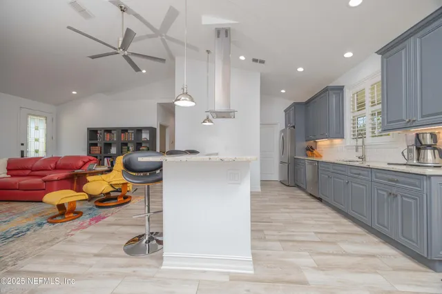 a large kitchen with stainless steel appliances granite countertop a lot of counter space and a sink