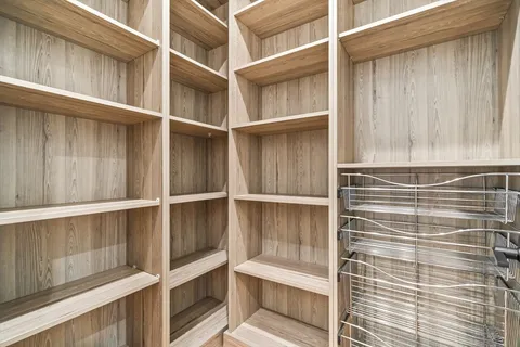 a view of walk in closet with empty racks