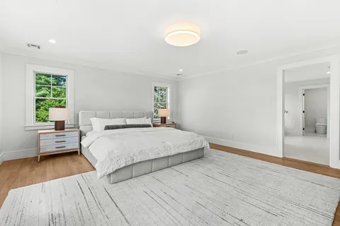 a spacious bedroom with a bed and wooden floor