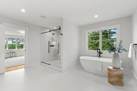 a spacious bathroom with a tub shower and windows