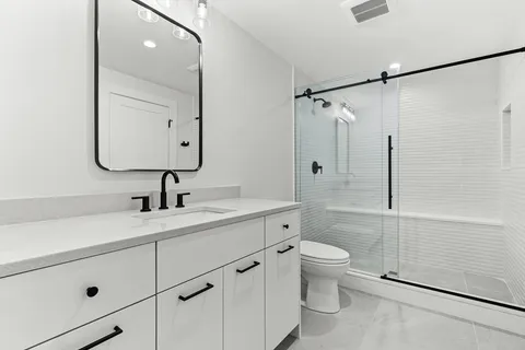 a bathroom with a sink a toilet and shower