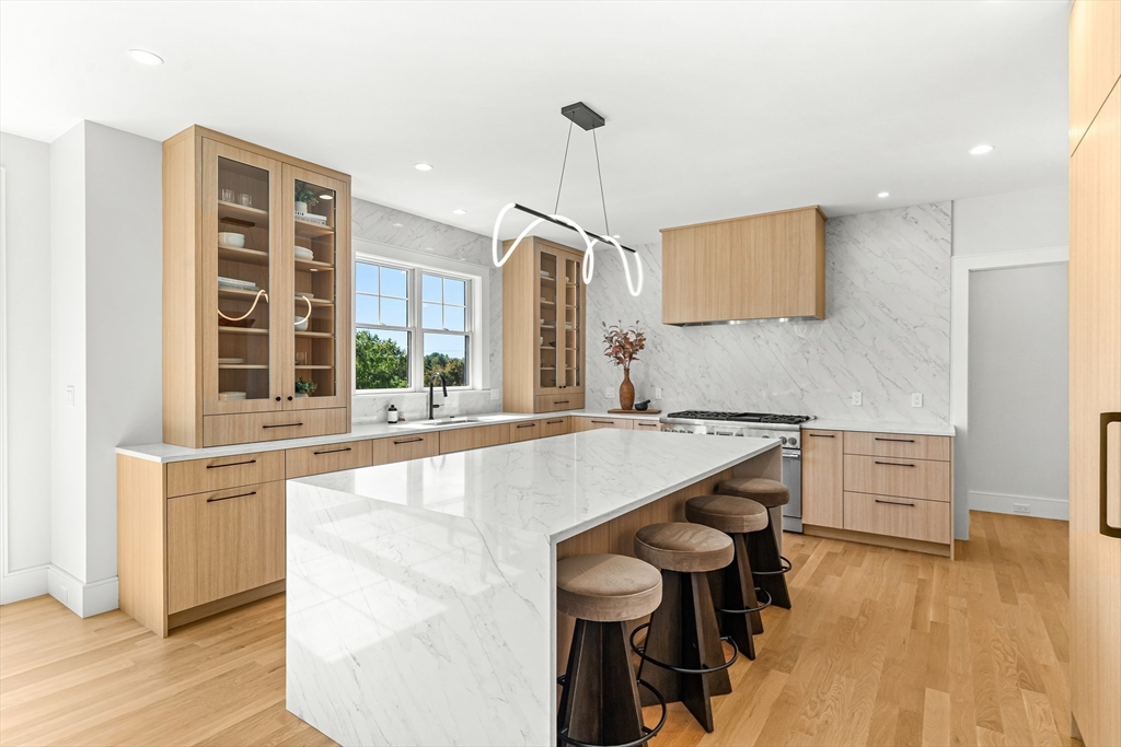 133 Lawton Road Needham, MA 02492 - Photo 4 of 36 a large kitchen with kitchen island a large counter space and wooden floor