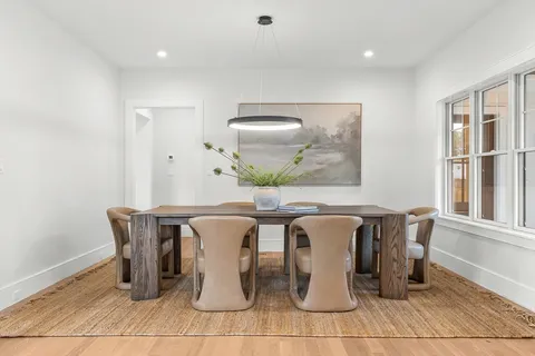 a dining room with chairs and view of kitchen
