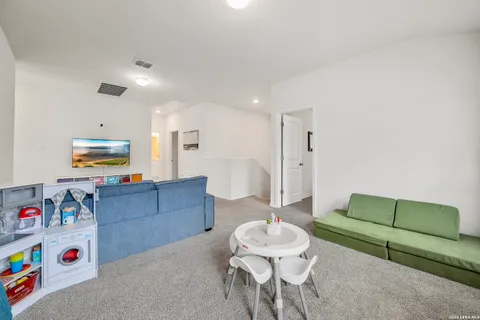 a living room with furniture and a dining table with kitchen view