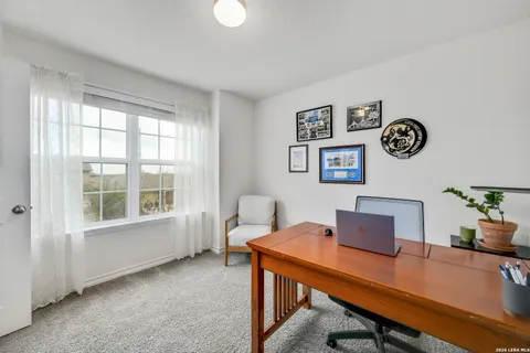 a view of a workspace with furniture and a window