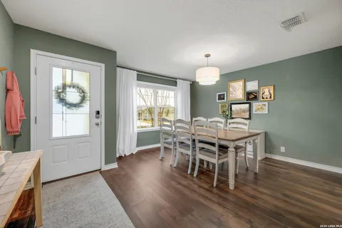 a dining room with furniture window and wooden floor