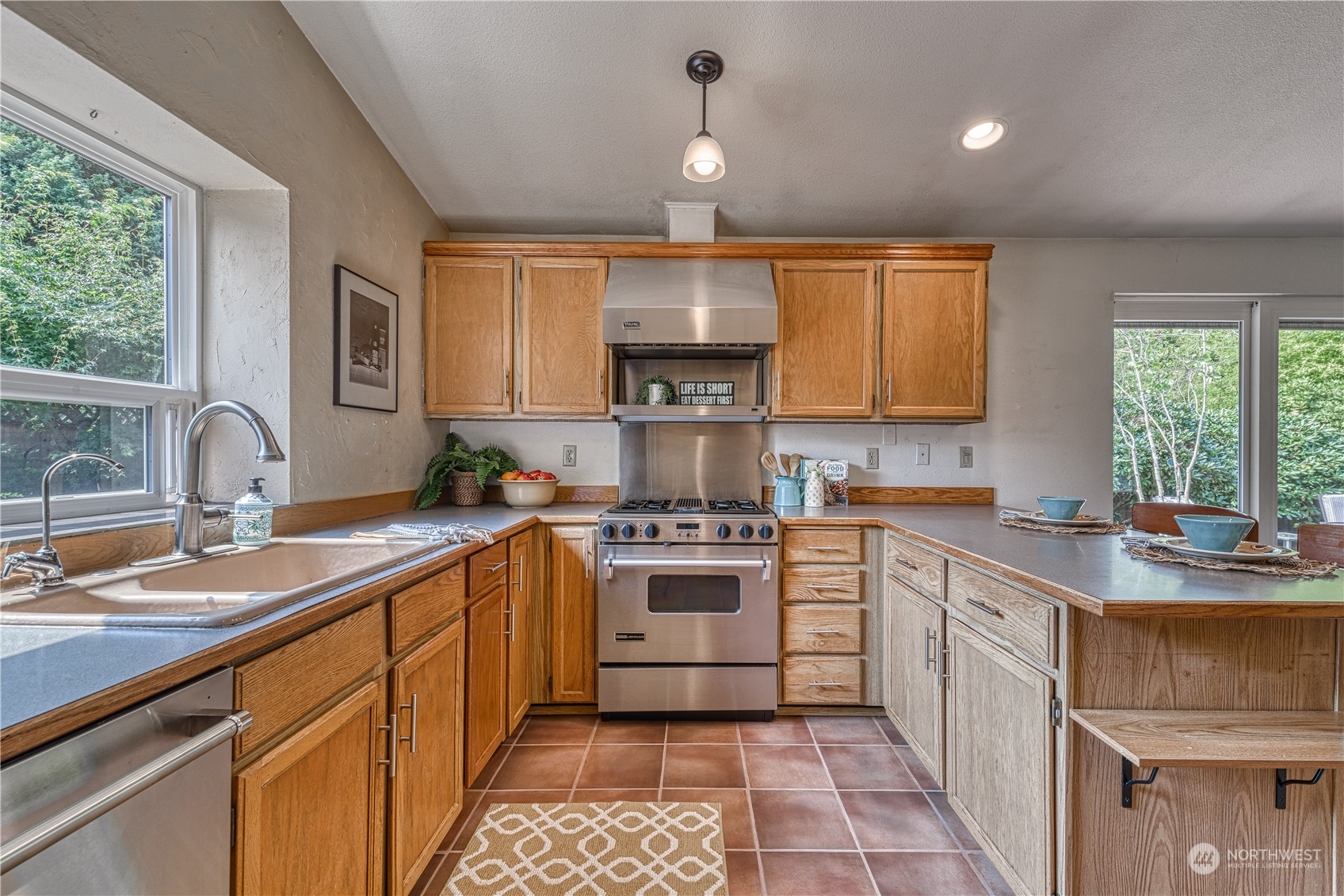 7720 Insel Avenue Gig Harbor, WA 98335 - Photo 13 of 29 a kitchen with a sink stove and cabinets