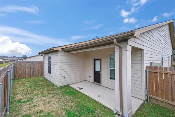 a backyard of a house with plants and wooden fence