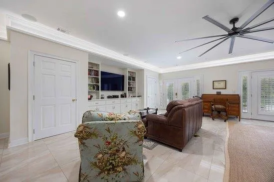 a living room with furniture ceiling fan and a flat screen tv