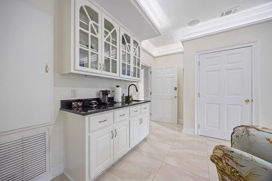 a kitchen with granite countertop a sink stove and cabinets