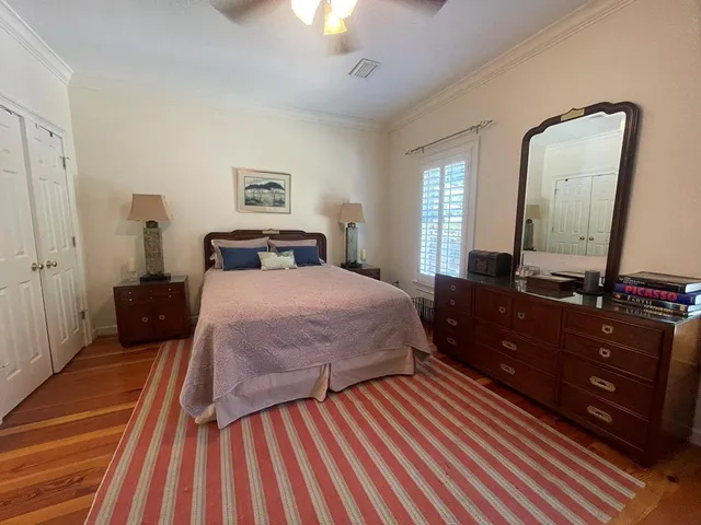 a bedroom with a bed and a mirror on dresser
