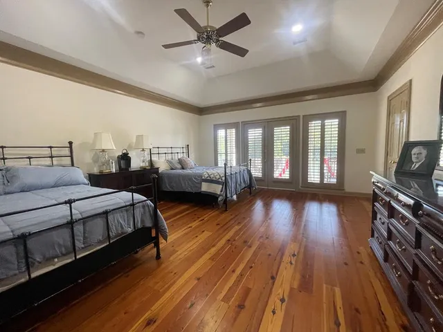 a spacious bedroom with two beds and wooden floor