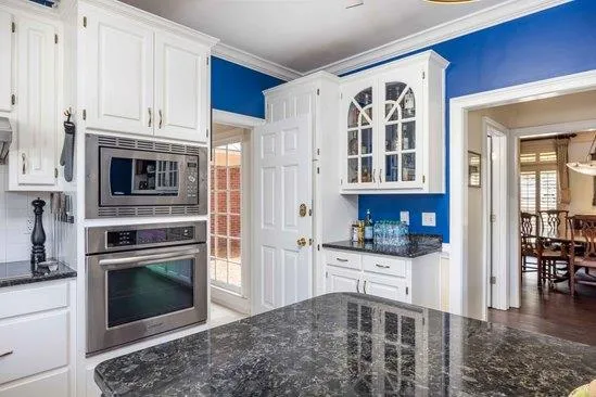 a kitchen with granite countertop a stove oven and cabinets