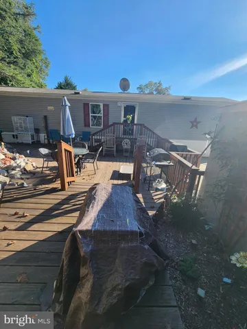 a view of a patio with couches table and chairs with wooden floor and fence