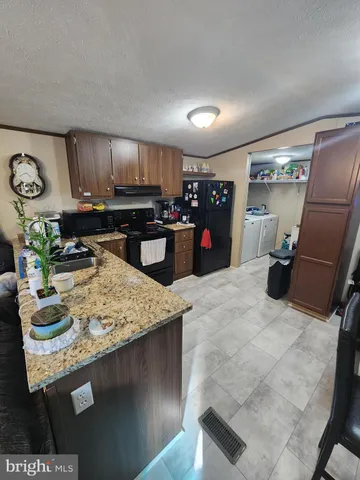 a kitchen with kitchen island granite countertop a sink stove and refrigerator