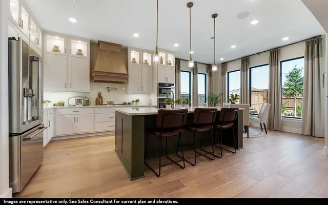a kitchen with a table chairs refrigerator and microwave