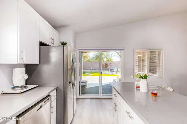 a kitchen with stainless steel appliances granite countertop a sink dishwasher stove top oven and refrigerator