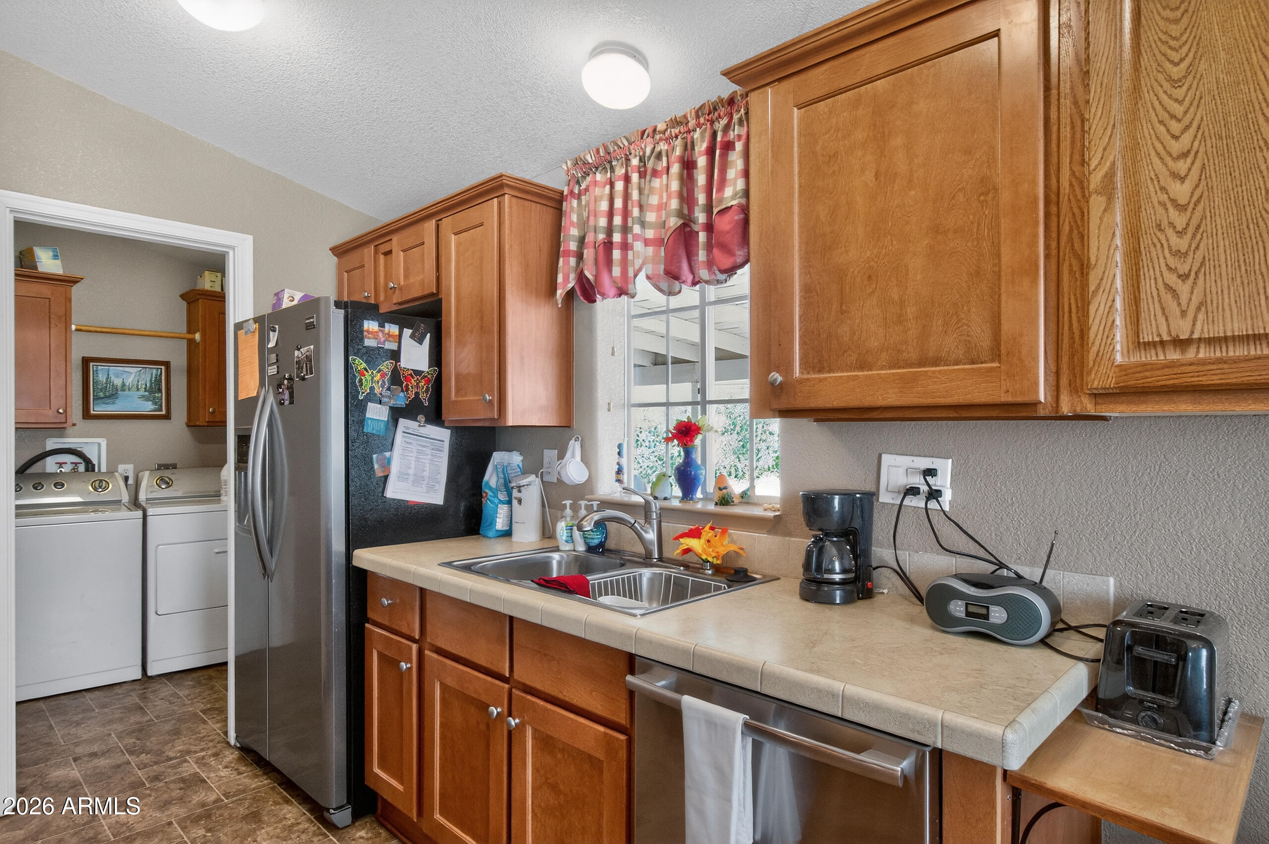 5735 East McDowell Road, Unit 408 Mesa, AZ 85215 - Photo 11 of 42 a kitchen with stainless steel appliances a sink dishwasher and cabinets with wooden floor