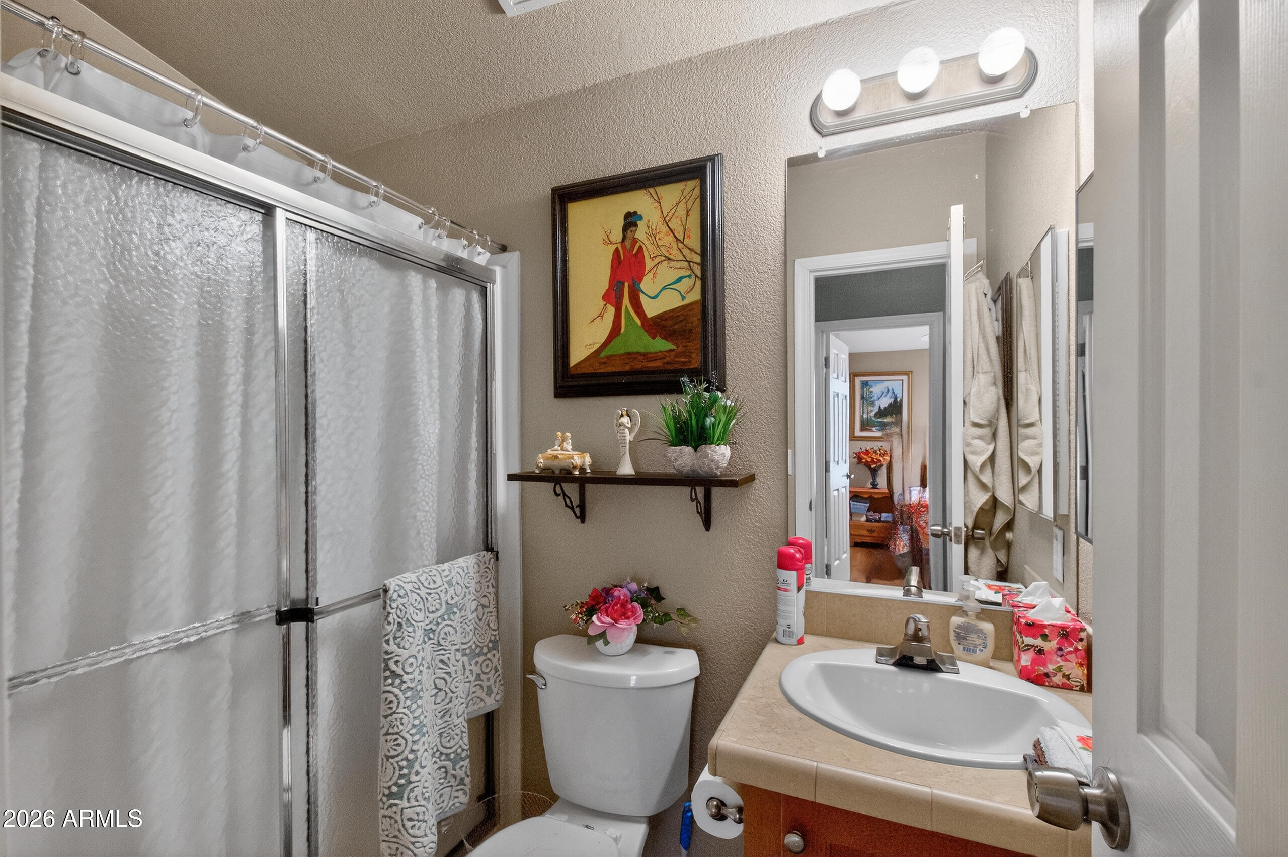 5735 East McDowell Road, Unit 408 Mesa, AZ 85215 - Photo 17 of 42 a bathroom with a sink mirror and toilet