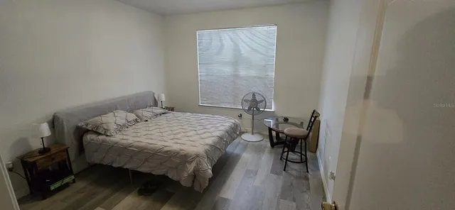 a bedroom with a bed and wooden floor
