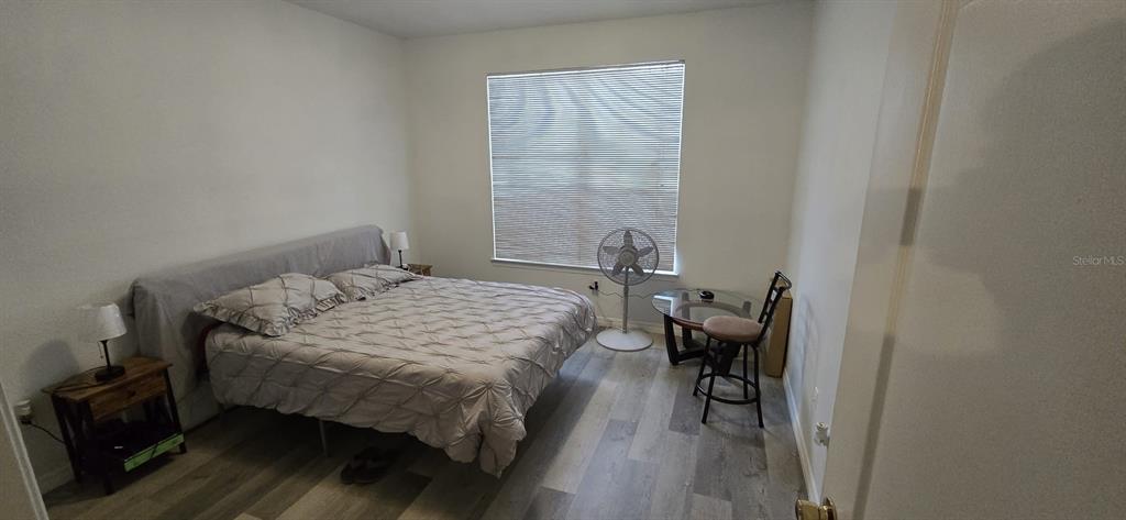 3379 South Kirkman Road, Unit 1015 Orlando, FL 32811 - Photo 7 of 9 a bedroom with a bed and wooden floor