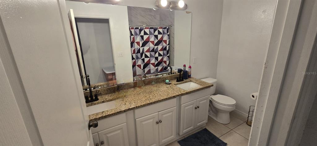 3379 South Kirkman Road, Unit 1015 Orlando, FL 32811 - Photo 8 of 9 a bathroom with a granite countertop sink toilet and shower