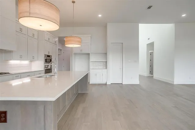 a kitchen with kitchen island a sink a center island and stainless steel appliances