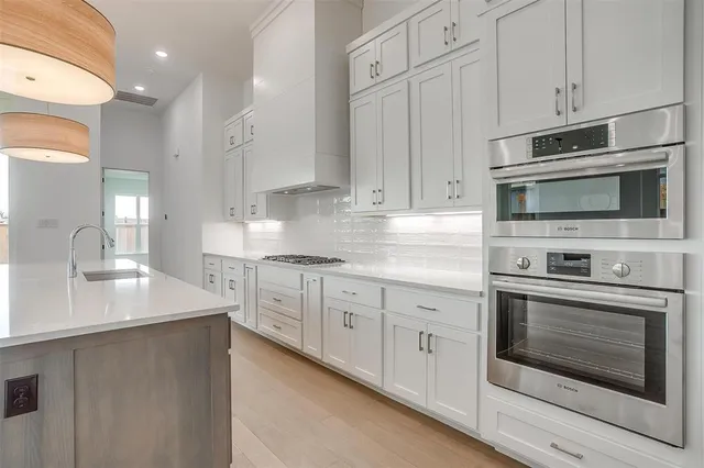 a kitchen with stainless steel appliances granite countertop white cabinets a sink and dishwasher