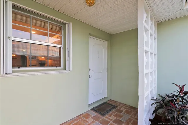 a view of an empty room with window and front door
