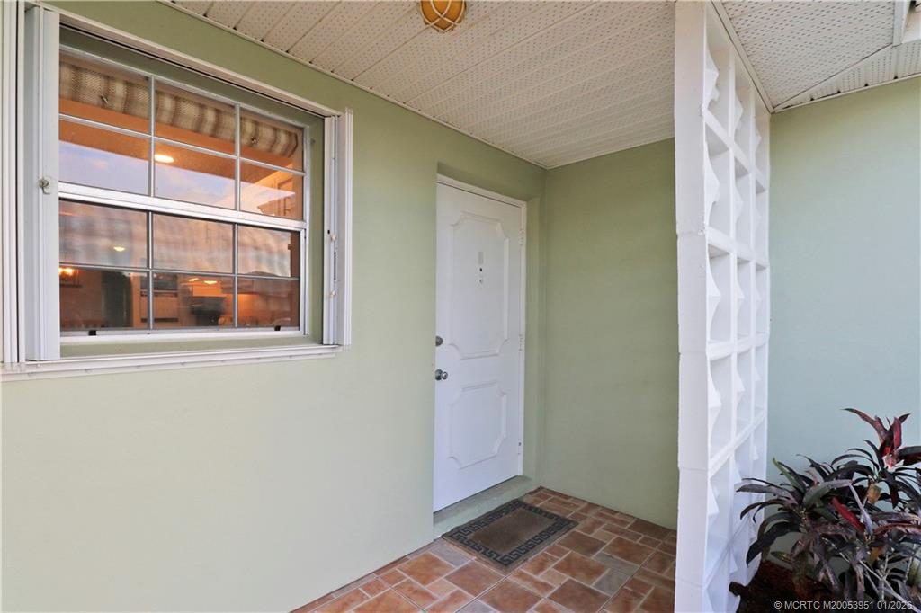 a view of an empty room with window and front door