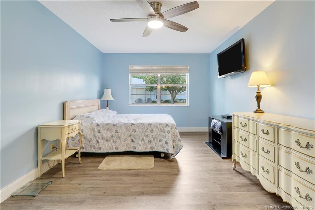211 Manatee Lane, Unit D Fort Pierce, FL 34982 - Photo 17 of 25 a bedroom with a bed and a flat tv screen on dresser