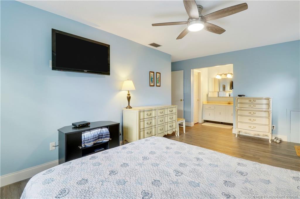 211 Manatee Lane, Unit D Fort Pierce, FL 34982 - Photo 18 of 25 a bedroom with a bed and a flat screen tv