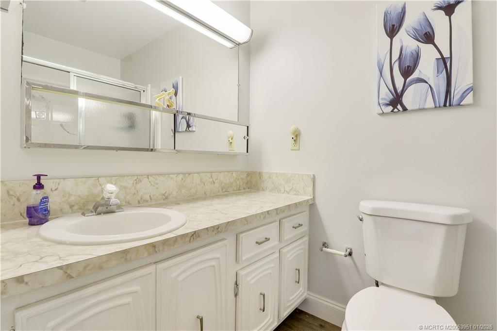211 Manatee Lane, Unit D Fort Pierce, FL 34982 - Photo 21 of 25 a bathroom with a toilet sink and mirror