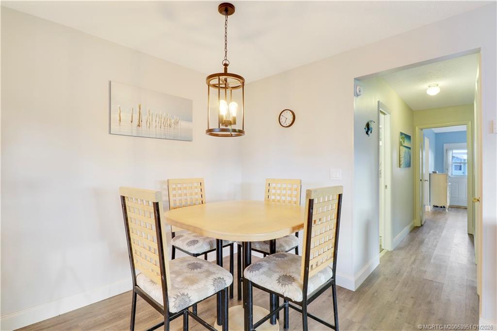 211 Manatee Lane, Unit D Fort Pierce, FL 34982 - Photo 9 of 25 a view of a dining room with furniture and wooden floor
