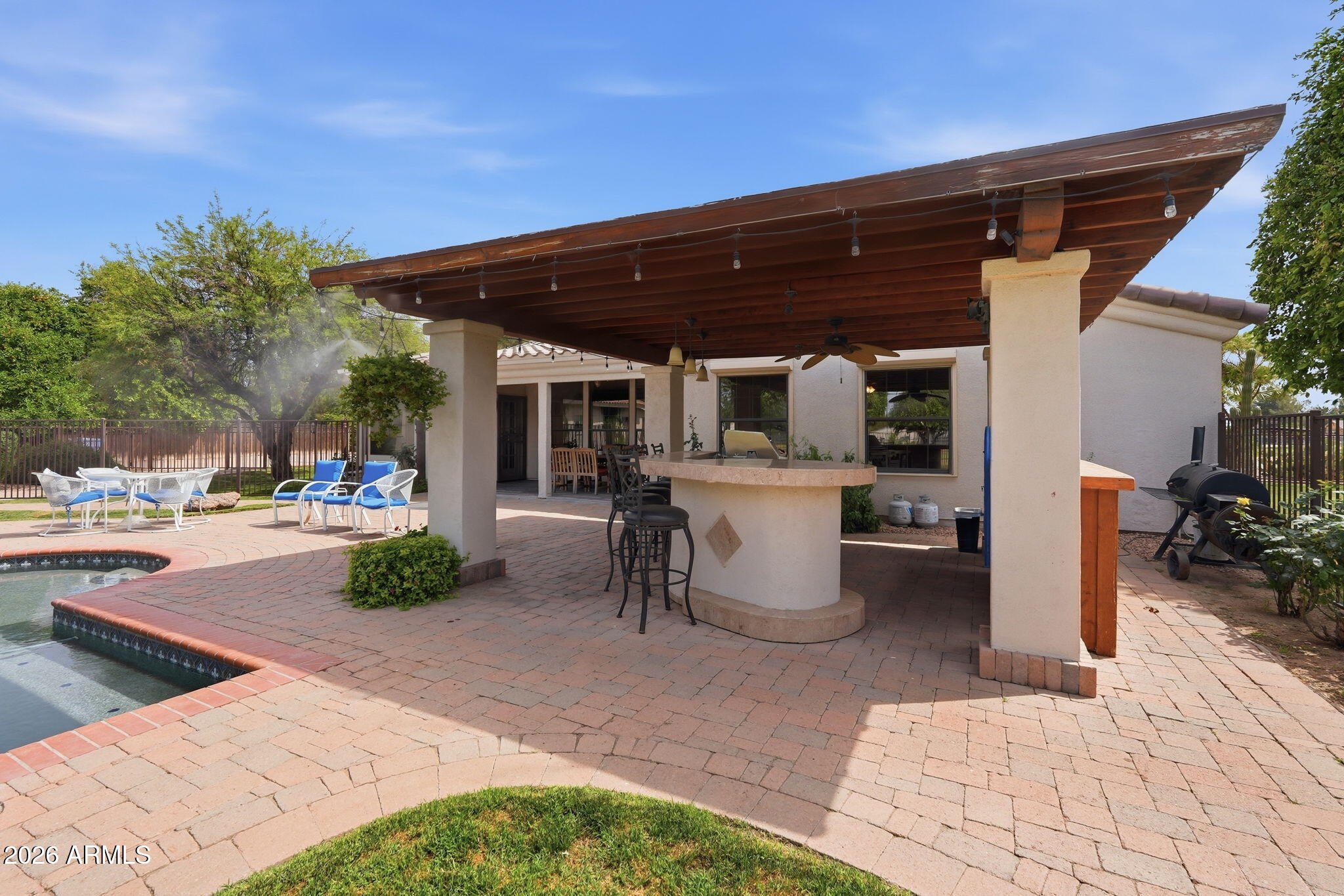 332 East Harrison Street Gilbert, AZ 85295 - Photo 20 of 101 a view of a patio with dining table and chairs under an umbrella