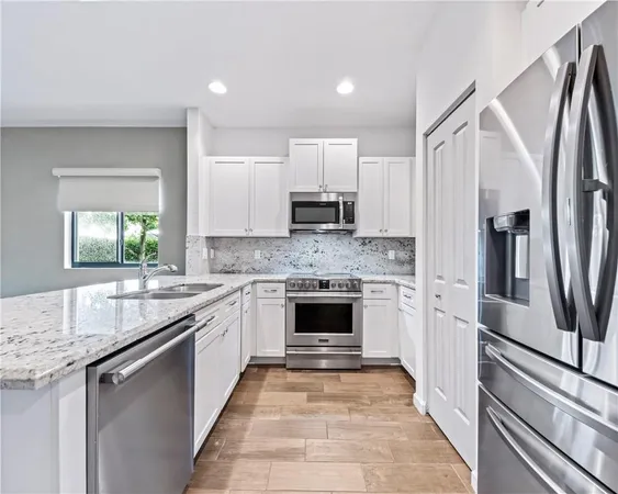 a kitchen with granite countertop a sink stove and refrigerator