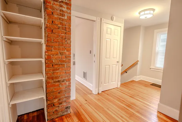 a view of a hallway with wooden floor and entryway