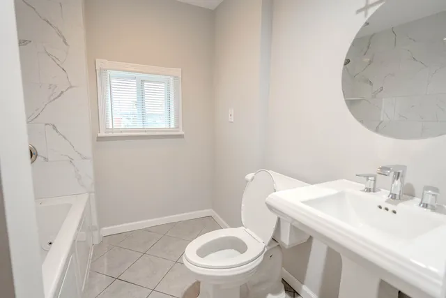 a bathroom with a sink a toilet and a mirror