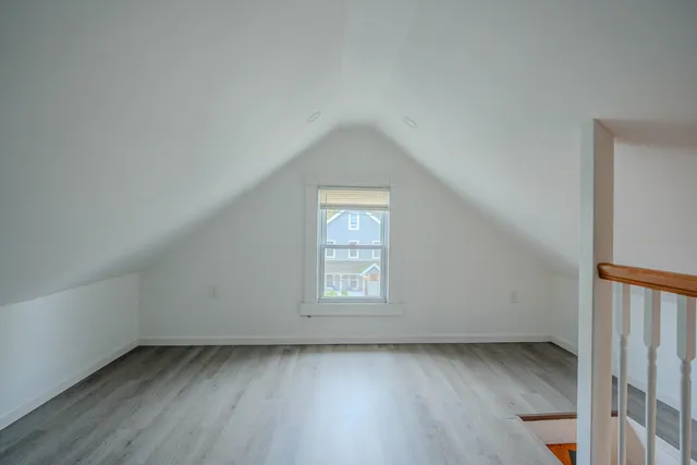 an empty room with wooden floor and window