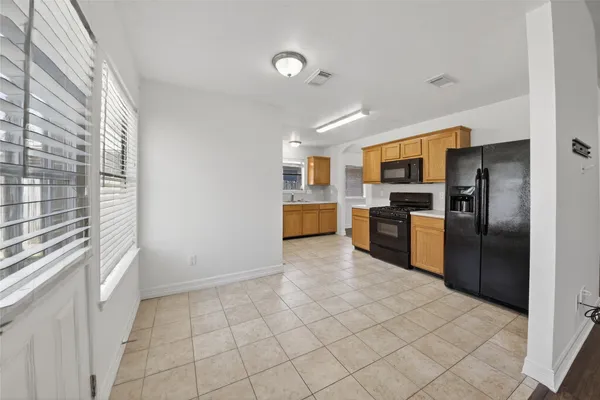 a kitchen with granite countertop a refrigerator and a stove top oven