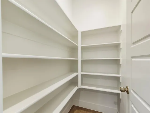 a view of walk in closet with empty racks