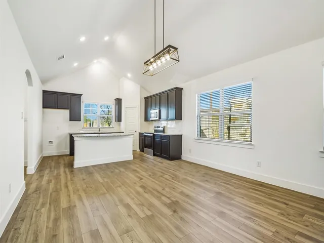 a kitchen with stainless steel appliances kitchen island a refrigerator sink and cabinets