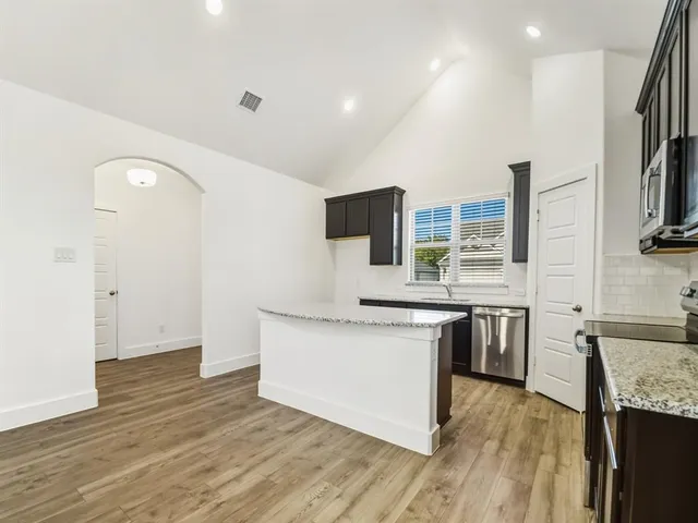 a kitchen with stainless steel appliances a stove top oven a sink and a refrigerator