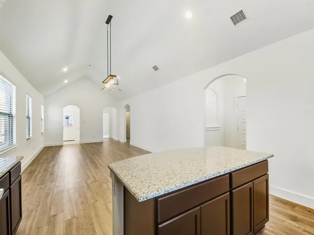 a kitchen with a sink a counter space and wooden floor