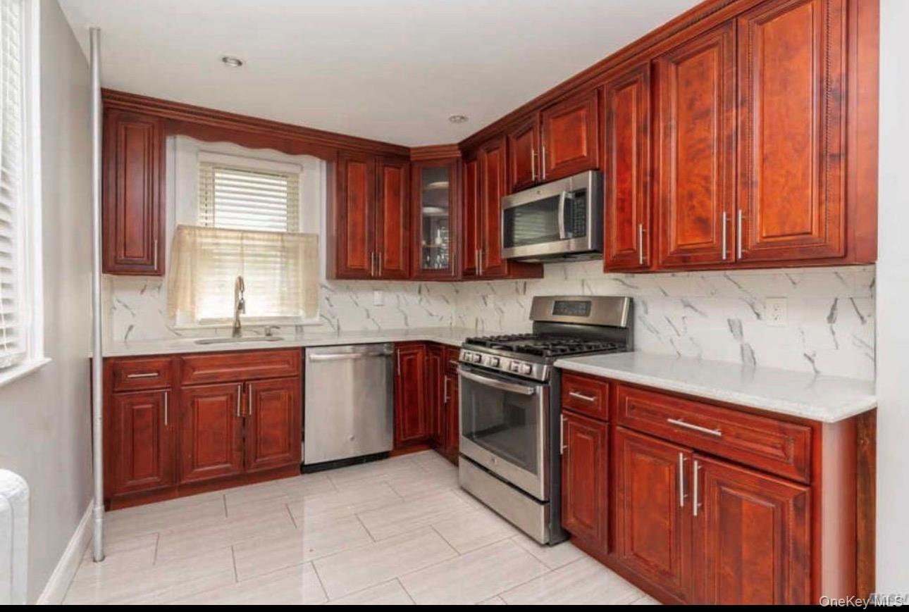 19 Hamilton Road Hempstead, NY 11550 - Photo 2 of 14 a kitchen with stainless steel appliances granite countertop a stove sink microwave and window