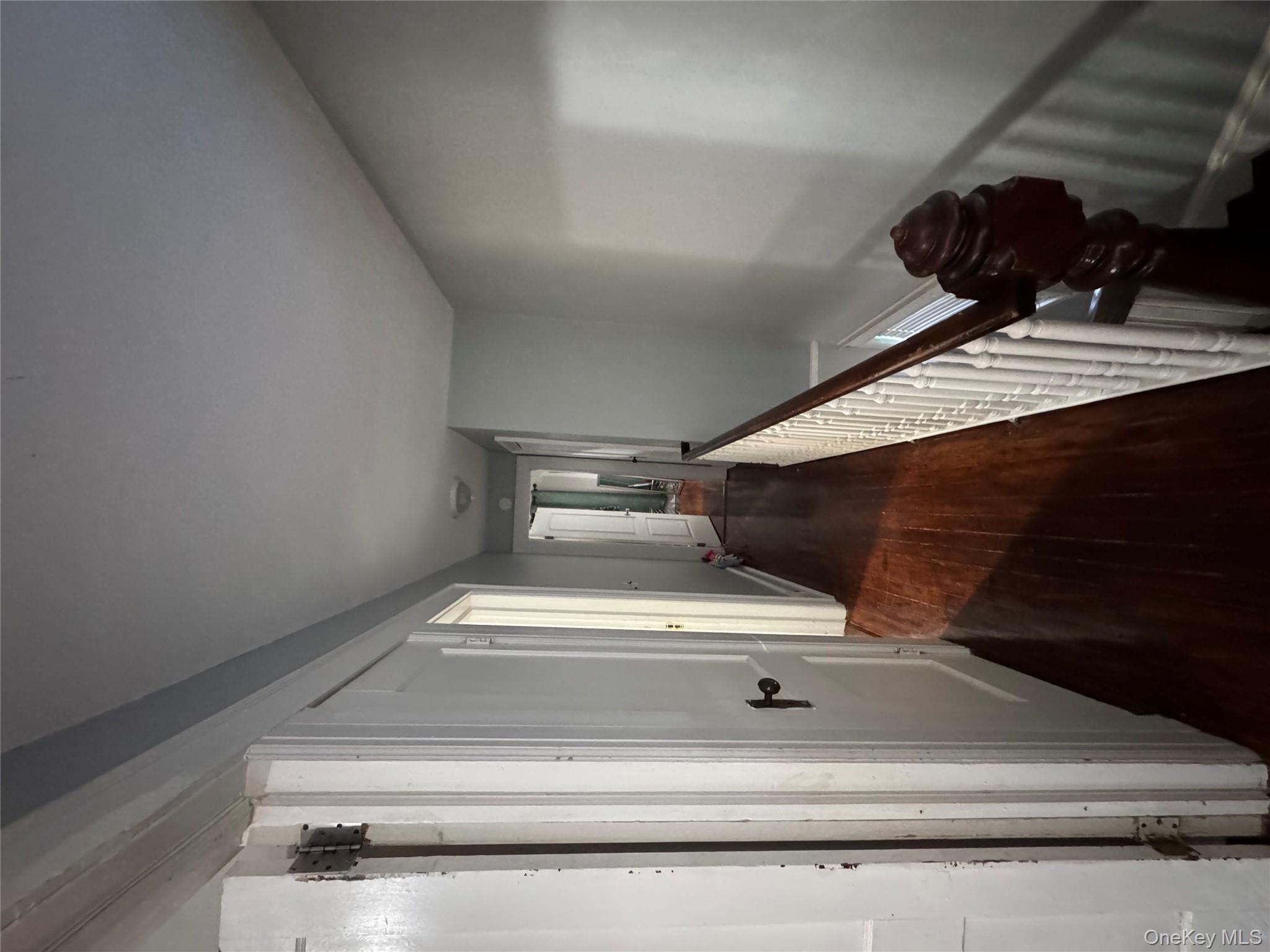 19 Hamilton Road Hempstead, NY 11550 - Photo 9 of 14 a view of a hallway to a livingroom with wooden floor and staircase