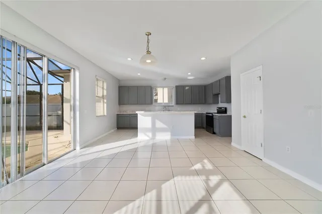 a large white kitchen with a large window and stainless steel appliances
